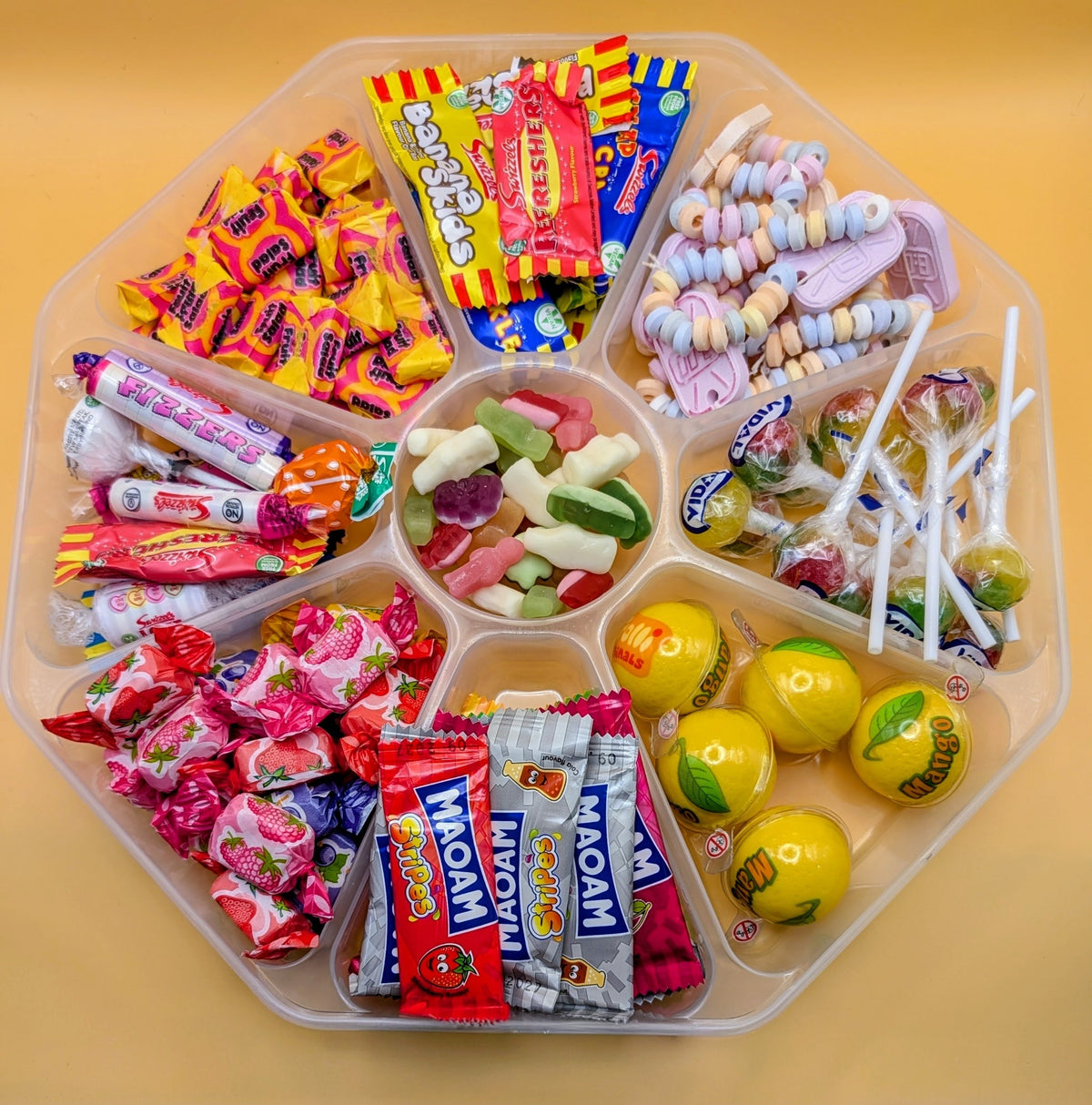 Sweet Feasts Candy Boards assorted retro sweet platter in a clear tray featuring lollipops, fruit chews, and candy.