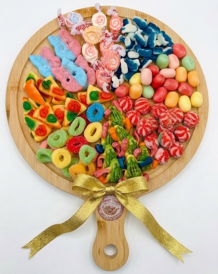 Sweet Feasts Candy Boards variety sweet platter on a rustic bamboo board with a gold ribbon bow